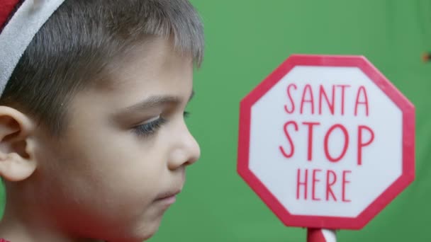 Söt Pojke Med Skylt Santa Stop Här Blinkar Isolerad Grön — Stockvideo