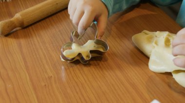 Zencefilli ekmek hamuru kesmek için kurabiye keskisi kullanan sevimli bir çocuk. Arkada Noel ağacı var. Yüksek kalite fotoğraf