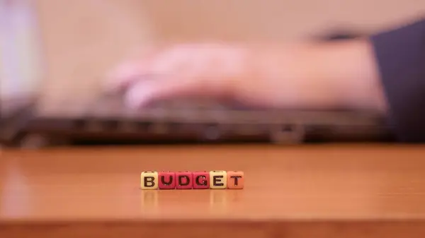 Budget. Hands using laptop with letters spelling budget. High quality photo