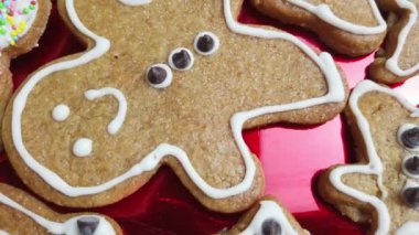 Beyaz krema ve çikolata parçacıklarıyla süslenmiş fırında pişmiş zencefilli kurabiye. Kırmızı plaka üzerinde dönüş. Yüksek kalite 4k görüntü