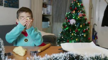 Tatlı elf çocuk Noel ağacının önünde zencefilli kurabiye yapıyor. Ağır çekim. Yüksek kalite 4k görüntü