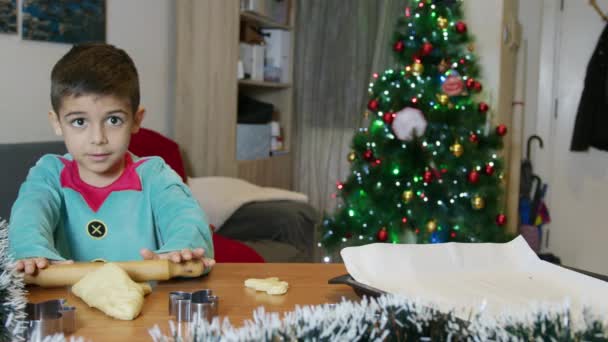 Cute Boy Elf Making Gingerbread Man Cookies Front Christmas Tree — Stock Video