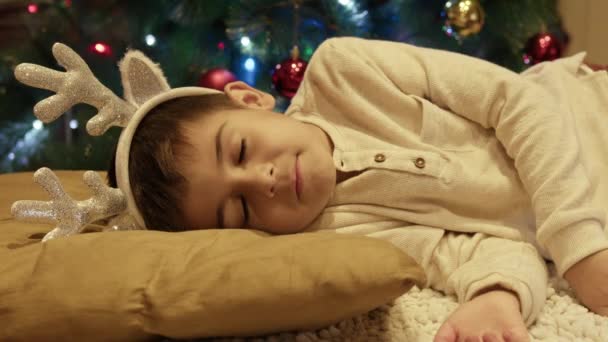 Słodki Chłopiec Śpiący Pobliżu Choinki Otwiera Oczy Jest Zaskoczony Wysokiej — Wideo stockowe
