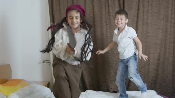 Nette Jungen Piratenkostümen Springen Auf Dem Bett Hochwertiges Filmmaterial — Stockvideo