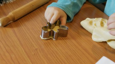 Zencefilli kurabiye keskisi kullanan ve Noel kurabiyesi yapan bir çocuk. Yüksek kalite fotoğraf