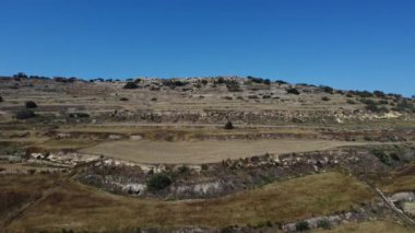 Tarım alanları, tepe terasları ve Il-Fortizza ta Selmun, tepenin üstündeki Campbell Kalesi. Mistra Bay, Malta 'dan hava görüntüsü. Yüksek kaliteli FullHD görüntüler
