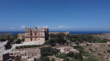 Selmun Sarayı 'nın ve Akdeniz' in arka tarafındaki çiftlik evlerinin havadan görünüşü. Yüksek kalite 4k görüntü