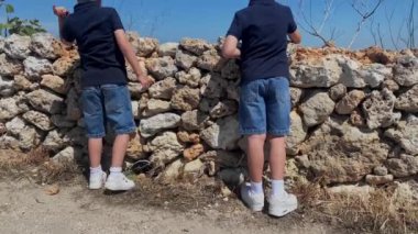İki çocuk, Selmun Sarayı yakınlarındaki bölgeyi keşfeden kardeşler, Malta. Yüksek kaliteli FullHD görüntüler