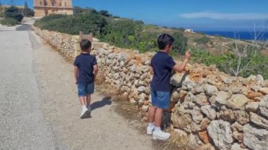 İki çocuk, Selmun Sarayı yakınlarındaki bölgeyi keşfeden kardeşler, Malta. Yüksek kaliteli FullHD görüntüler