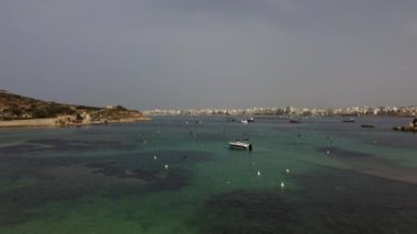Malta, Mistra Körfezi 'nde tekneler ve balıkçı çiftlikleri var. Arka planda St Pauls Körfezi. Yüksek kalite 4k görüntü