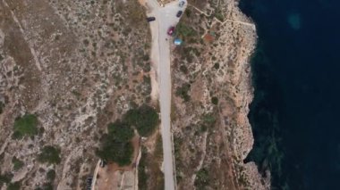 Malta, Mstra Körfezi, kıyı yolunun havadan görünüşü 18. yüzyılda Aziz John Tarikatı tarafından inşa edilen Mistra bataryasını gösteriyor. Kıyı tahkimatı. Çekim başlıyor. Yüksek kalite 4k görüntü