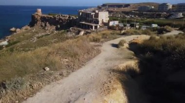 Bir kadın yürüyüşçünün gölgesi ve Tuffieha Körfezi Manzarası - Ghajn Tuffieha veya Riviera Sahili, Singita Miracle Sahili. Zaman ayarlı. Yüksek kalite 4k görüntü