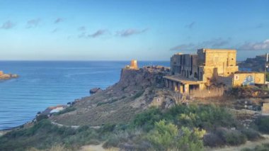 Malta Ghajn Tuffieha Körfezi, 2. Dünya Savaşı Pillbox, Gözetleme Kulesi ve terk edilmiş bina. Altın kum plajı ortaya çıkıyor. Yüksek kalite 4k görüntü