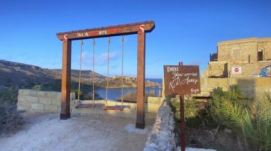 Ghajn Tuffieha, Malta 27.05.2024 - Tuffieha körfezi veya ramla körfezi sahili yakınlarındaki merdivenlerde salıncak ve mesaj panoları. Singita mucizevi sahil girişi. Malta 'ya aşık ol. Yüksek kalite 4k görüntü