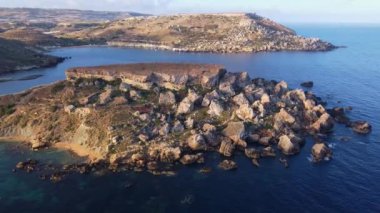 Qarraba Körfezi düz kaya pelerini Malta, sabah güneş ışığında havadan çekim yapılıyor. Yüksek kalite 4k görüntü