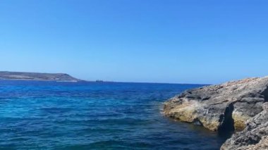 Dalgalar kayalık sahile çarpıyor, zaman geçiyor. Yüksek kalite 4k görüntü