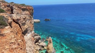 Comino Adası 'ndaki güzel kireçtaşı uçurumunun havadan görünüşü bir file benziyor. Kıyıdaki turkuaz deniz suyuna sadece tekneyle ulaşılabilir. Yüksek kalite 4k görüntü