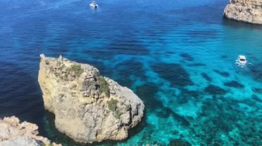 Akdeniz 'de kristal berrak su ve tekneleri olan dev bir kaya. Yüksek kalite 4k görüntü