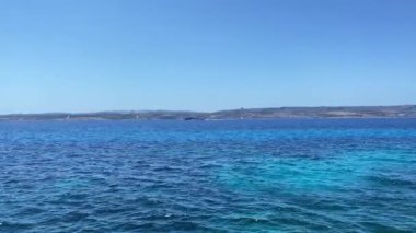 Güzel ve sakin Akdeniz 'de Malta adası kıyılarına yakın bir tekne gezintisi. Comino sahilinden görülmüş. Yüksek kalite 4k görüntü