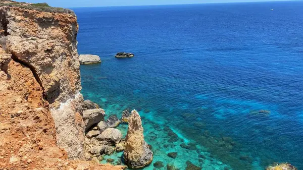 Comino Adası 'ndaki güzel kireçtaşı uçurumunun havadan görünüşü bir file benziyor. Kıyıdaki turkuaz deniz suyuna sadece tekneyle ulaşılabilir. Yüksek kalite fotoğraf