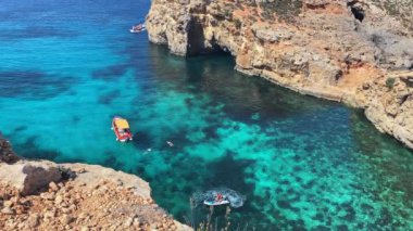 Lüks bir tatil. Tekneyle Comino mağaralarını, deniz motorsikletlerini ve kanoyu ziyaret etmek. Malta, Akdeniz. Yüksek kalite 4k görüntü