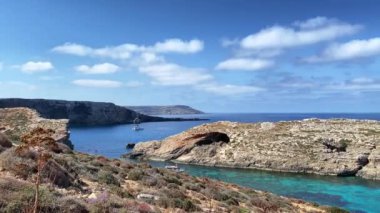 Comino, Malta 28.05.2024 - Akdeniz suyunda yüzen teknelerle taşın içindeki doğal pencereler. Yüksek kalite 4k görüntü