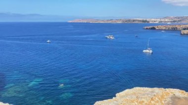 Comino Malta. l-iskoll ta Taht il-mazz ve Il-Bejta tl-fenek gölünün manzarası. Teknelerin yaklaştığı kıyı mağaraları. Yüksek kalite 4k görüntü
