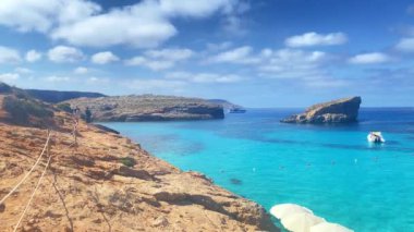 Comino, Malta 28.05.2024 - Malta Comino Adası 'ndaki kristal berrak turkuaz su içinde yüzen küçük tekne. Yüksek kalite 4k görüntü