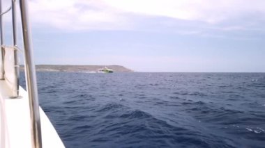 Cirkewwa, Malta 29.05.2024 - Güvertenin üstünden bir manzara, yatın açık denizde dalgalanması. Yüksek kalite 4k görüntü