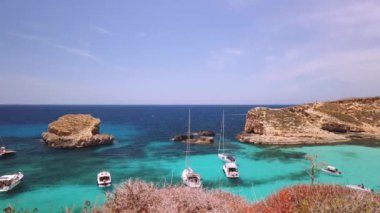 Comino, Malta 29.05.2024 - Blue Lagoon yakınlarında demirlemiş tekneler, küçük adanın etrafında yelken açarak Comino mağaralarını ziyaret ediyorlar. Yüksek kalite 4k görüntü
