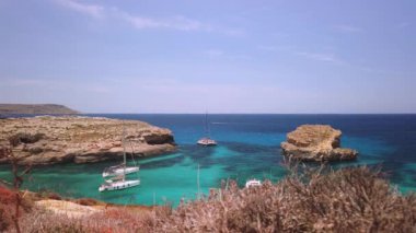 Comino, Malta 29.05.2024 - Blue lagoon yakınlarında demirli tekneler, Cominotto adasının arkasında. Atış serbest. Yüksek kalite 4k görüntü