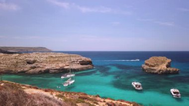 Comino, Malta 29.05.2024 - Blue Lagoon yakınlarında demirlemiş tekneler, küçük adanın etrafında yelken açarak Comino mağaralarını ziyaret ediyorlar. Yüksek kalite 4k görüntü