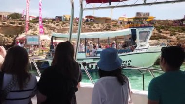 Comino, Malta 29.05.2024 - Mavi Göl. Teknedeki turistler Comino adasındaki limana yaklaşıyorlar. - Evet. Yüksek kalite 4k görüntü