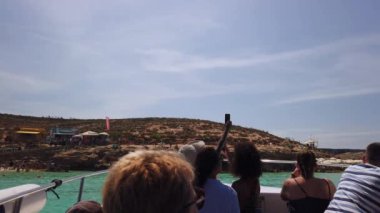 Comino, Malta 29.05.2024 - Mavi Göl. Teknedeki turistler Comino adasındaki limana yaklaşıyorlar. Fotoğraf çekiyordum. Yüksek kalite 4k görüntü