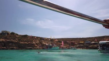 Comino, Malta 29.05.2024 - Mavi lagün limanına yaklaşan feribot. Yaz tatili ve tekne turu. Yüksek kalite 4k görüntü