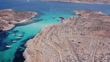 Malta 'nın bir parçası olan Comino adasının havadan görünüşü. Mavi göl, yaz, tekneler, mavi deniz. İHA atışı ayarlanıyor. Yüksek kalite 4k görüntü