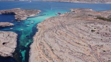 Malta 'nın bir parçası olan Comino adasının havadan görünüşü. Mavi göl, yaz, tekneler, mavi deniz. İHA atışı ayarlanıyor. Yüksek kalite 4k görüntü