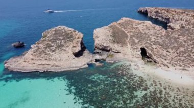 Issız Cominotto Adası 'ndaki güzel kumsal ve Malta' daki Blue Lagoon Comino. Havadan yörünge atışı. Yüksek kalite 4k görüntü