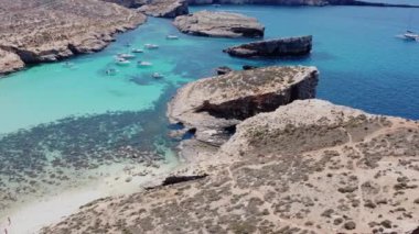 Issız Cominotto Adası 'ndaki güzel kumsal ve Malta' daki Blue Lagoon Comino. Havadan yörünge atışı. Yüksek kalite 4k görüntü