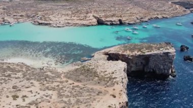 Issız Cominotto Adası 'ndaki güzel kumsal ve Malta' daki Blue Lagoon Comino. Havadan yörünge atışı. Yüksek kalite 4k görüntü