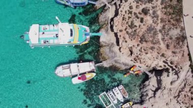 Comino, Malta - 29.05.2024 - Blue Lagoon yakınlarındaki Comino Adası iskelesinde demirli tekne ve yat. Hava görüntüsü. Yüksek kalite 4k görüntü