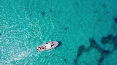 Kristal berrak turkuaz deniz suyuyla giden bir tekne. Tropik tatil. Yüksek kalite 4k görüntü