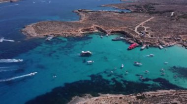 Comino, Malta - 29.05.2024 - Malta 'nın bir parçası olan Comino adasının havadan görünüşü. Mavi göl, yaz, tekneler, mavi deniz. İHA atışı ayarlanıyor. Yüksek kalite 4k görüntü