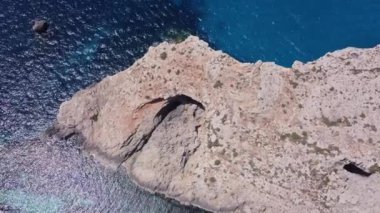 Comino Adası Malta 'daki kayalıklardaki doğal pencereler insansız hava aracı atışını gözler önüne seriyor. Yüksek kalite 4k görüntü
