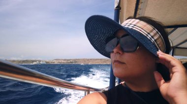 Güneş gözlüklü ve şapka takan orta yaşlı bir kadın. Yüksek kalite fotoğraf