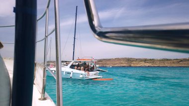 Comino, Malta 29.05.2024 - Comino Adası Malta 'nın turkuaz sularında demirli yat, yaz tatili. Adadan ayrılan gemideki POV. Yüksek kalite fotoğraf