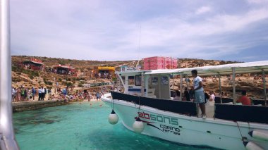 Comino, Malta 29.05.2024 - Comino Adası Malta 'nın turkuaz sularında demirli yat, yaz tatili. Adadan ayrılan gemideki POV. Yüksek kalite fotoğraf