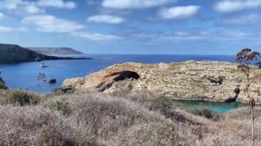 Comino, Malta 28.05.2024 - Akdeniz suyunda yüzen teknelerle taşın içindeki doğal pencereler. Yüksek kalite 4k görüntü