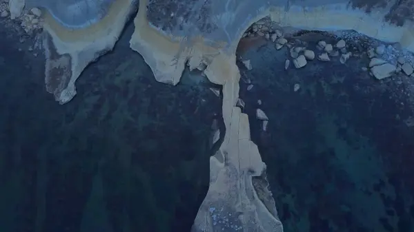 stock image Tat-Tonn or Spritzing rock, snorkeling point between Qarraba Bay and TaBabu Cove, Ghajn Tuffieha, Mgar, Malta. Aerial view of the emerald sea and rocky coast in early morning still in the shade of