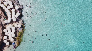 İnsanlar kristal berrak turkuaz deniz suyunda yüzüyorlar. Comino Adası, Malta, Havadan yukarıdan aşağıya doğru görüş. Yüksek kalite fotoğraf